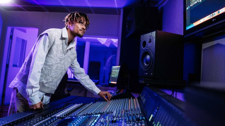 Music industry studies major working with a mixing board in University of the Pacific's recording studio
