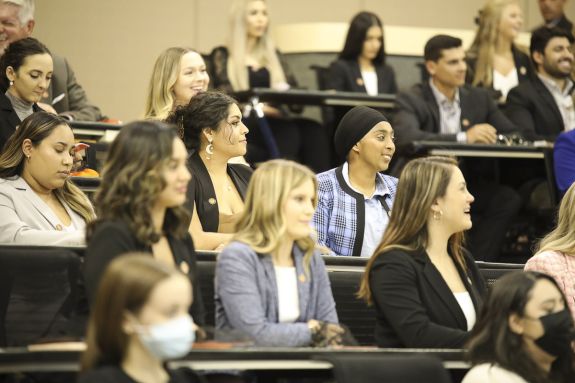 A group of students sits in a lecture hall.