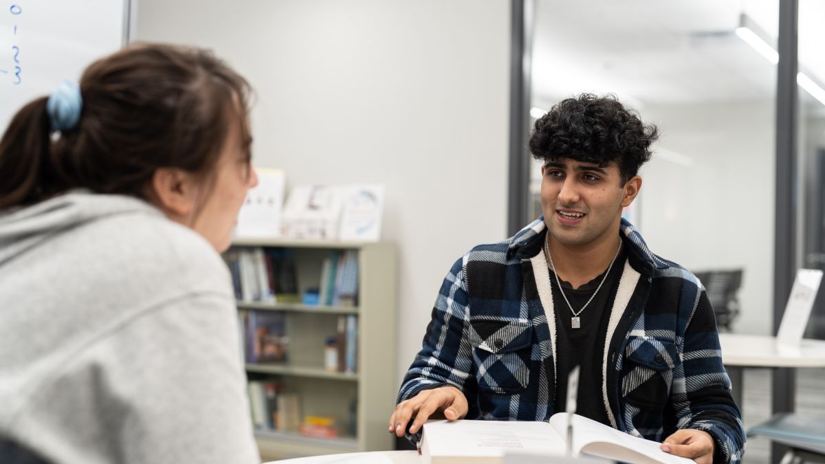 two students sitting at a table in the tutoring center