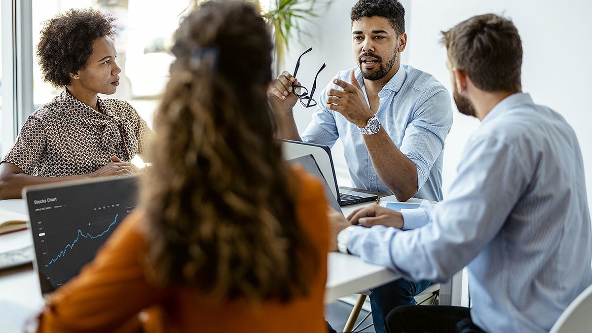 four people sitting at an office table
