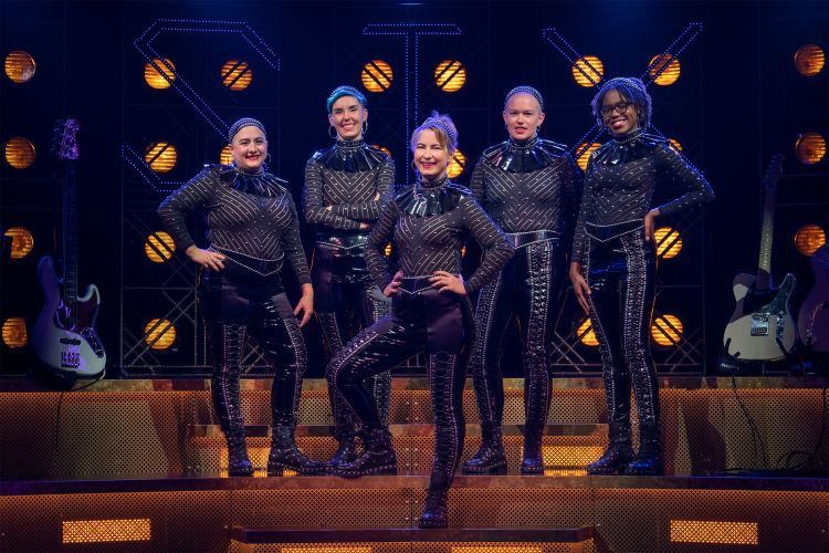 Six women dressed in costume stand together for a group photo