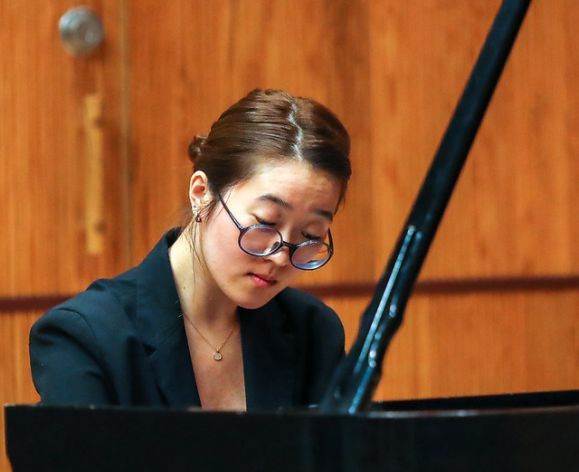 a woman plays the piano