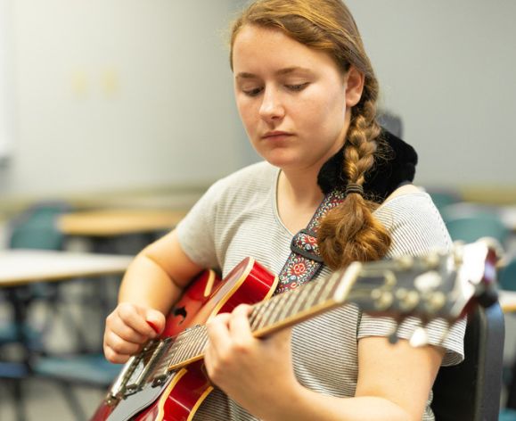 a girl playing a guitar