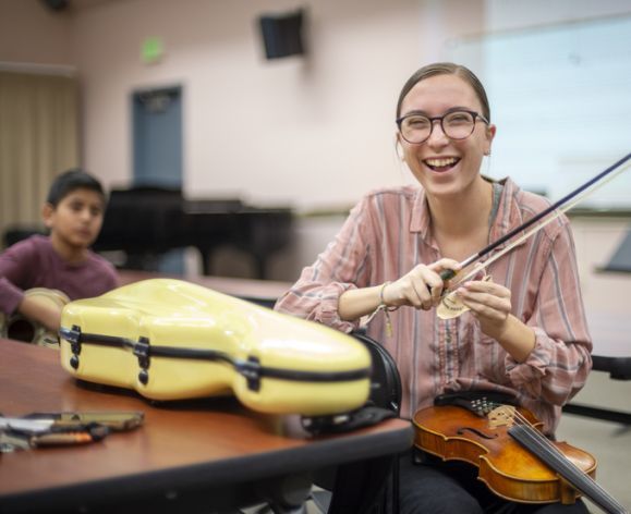 a happy music teacher with a violin